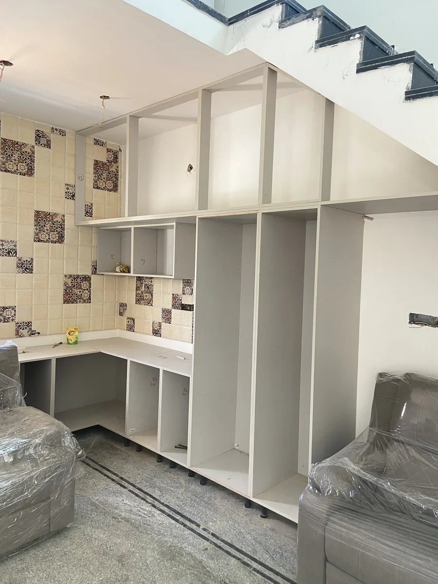 Villa interior in Bengaluru by AlcorOne Solutions — Under-stair storage & study unit during installation