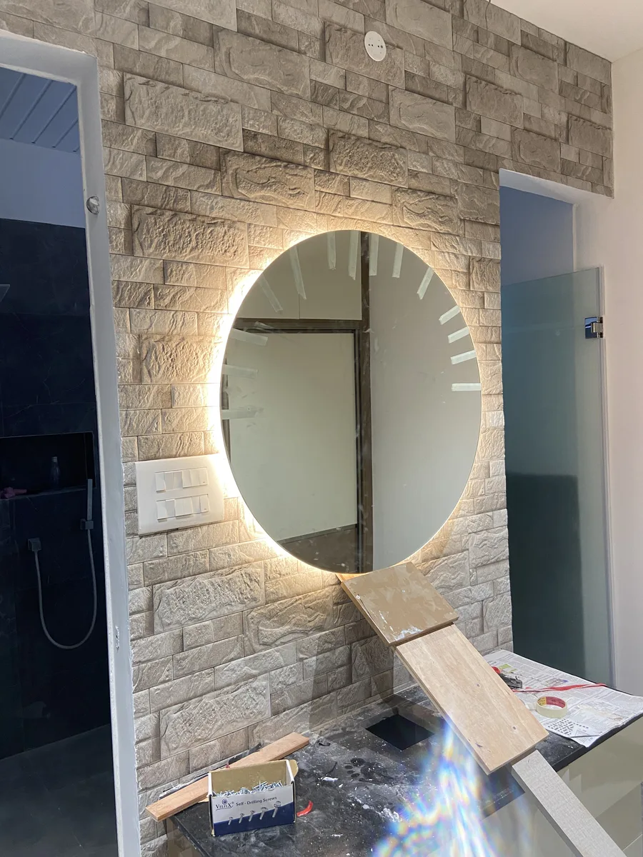 Villa interior in Hyderabad by AlcorOne Solutions — Backlit mirror & stone-clad wall